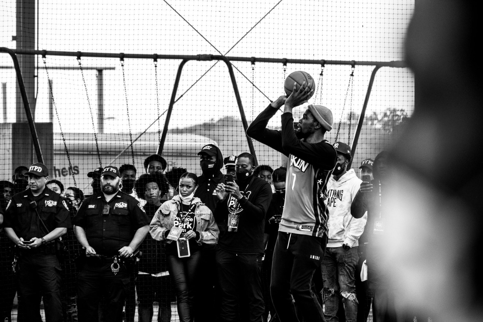 a man holding a basketball in front of a group of people